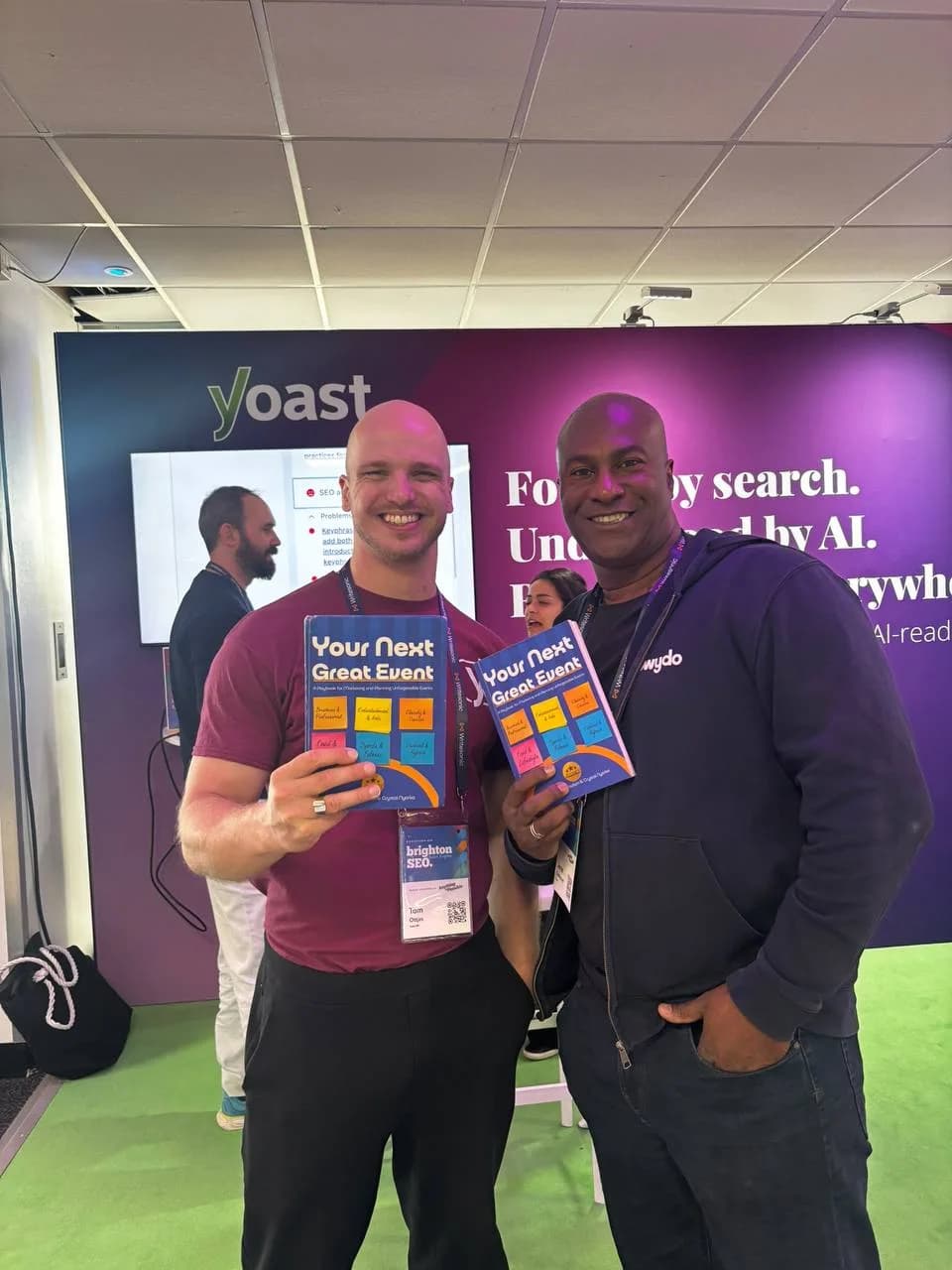 Two attendees smiling with copies of Your Next Great Event